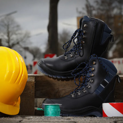 Schwarze Winter Sicherheitsstiefel Oslo S3S mit blauen Schnürsenkeln und Webpelzfutter, neben einem gelben Helm.